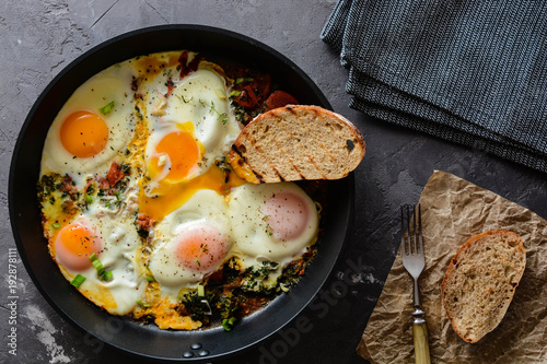 fried eggs with spinach, tomatoes and toasted bread.