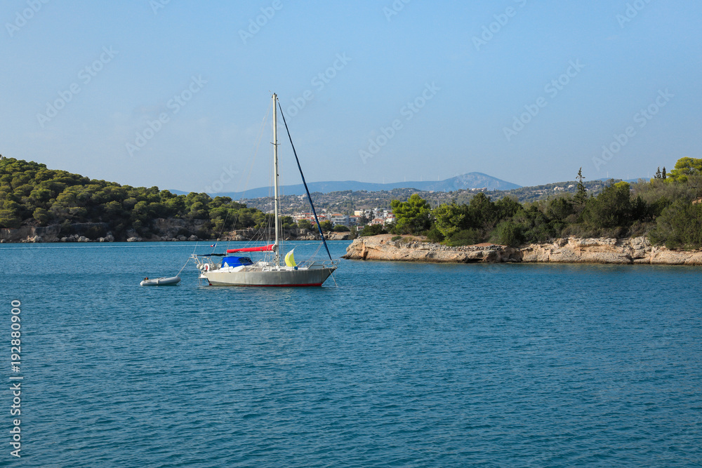 A sailing boat anchoring in a bay near Porto Heli, Peloponnese, Greece.