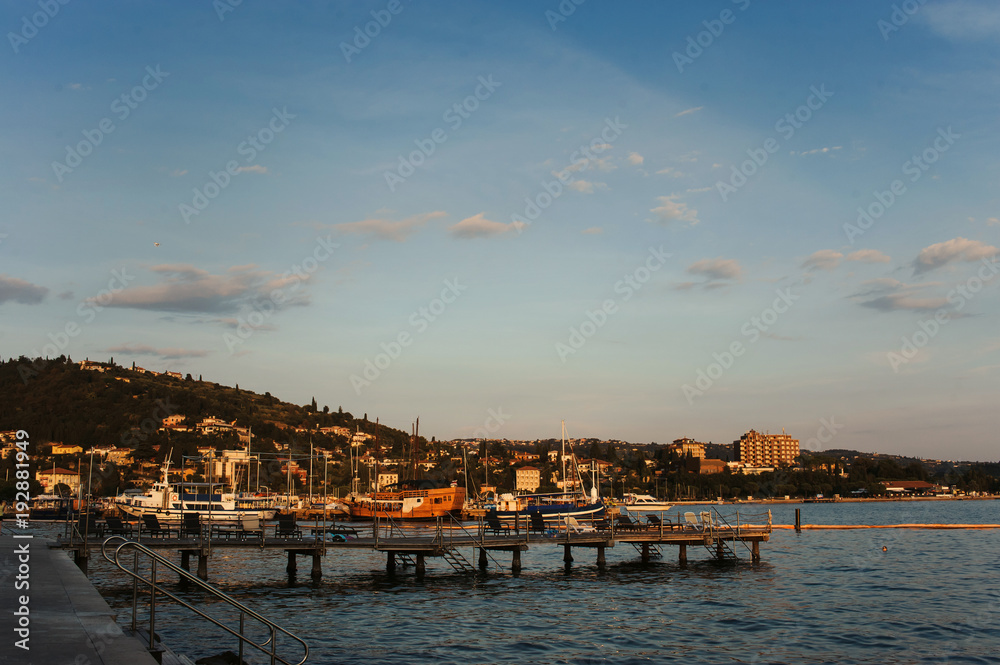 Marine with yachts and sail boats and town view at sunset. Portoroz