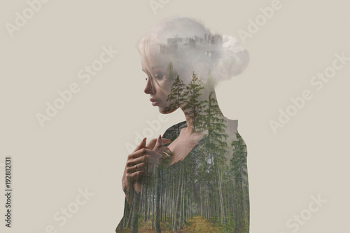 Double exposure. Creative. Beautiful girl with a forest and trees inside the body. Gray background