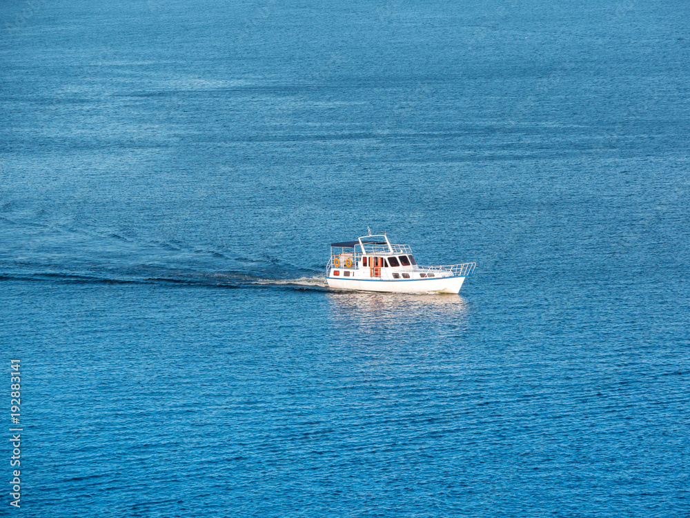 Small boat on the sea or on the river. Blue water with small waves