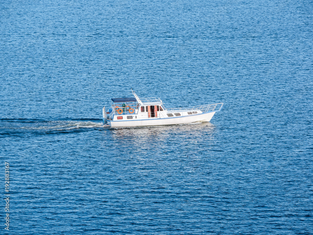 Small boat on the sea or on the river. Blue water with small waves Small boat on the sea or on the river. Blue water with small waves