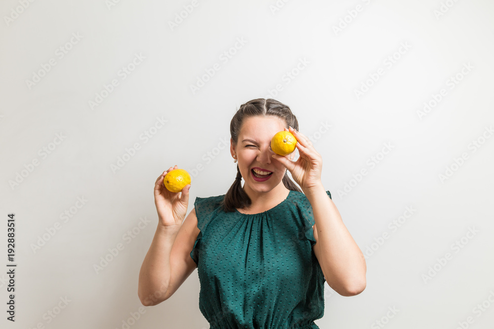Cute girl whinks and holds lemon fruits Cute girl whinks and holds lemon fruits