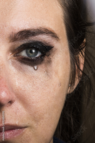 Woman crying with light eyes with blurred makeup