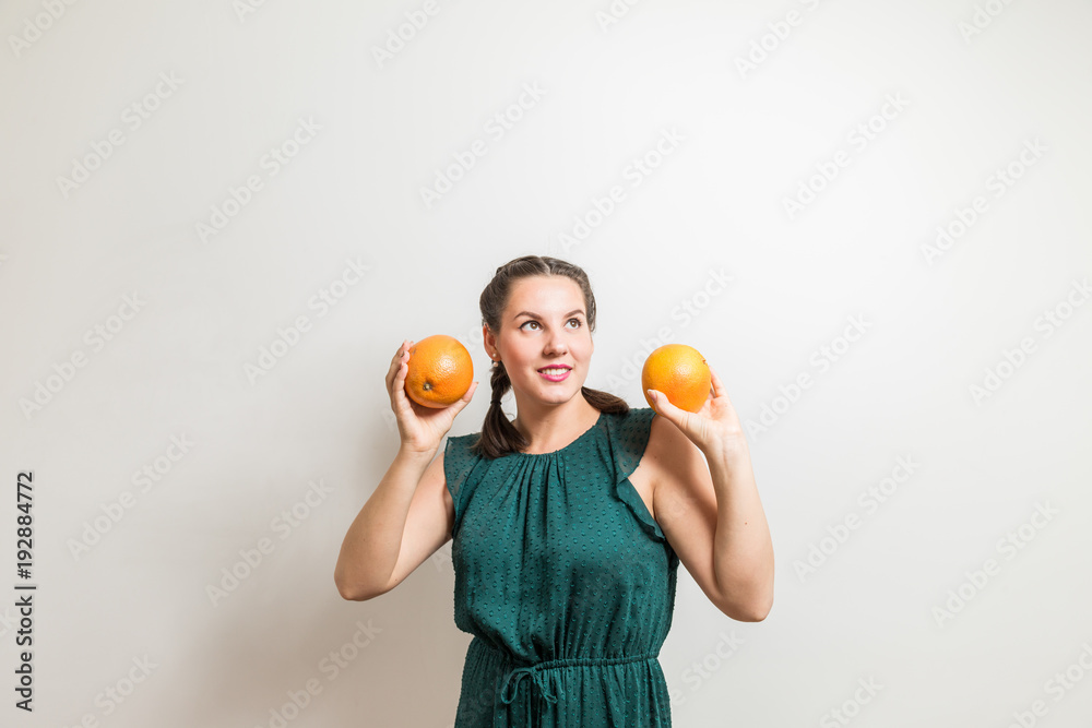 Cute happy girl lifts grapefruits