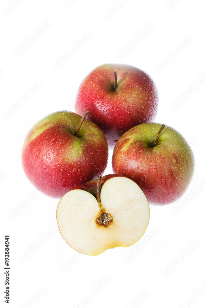 Four apples on a white background. One cut in half. Four apples on a white background. One cut in half.