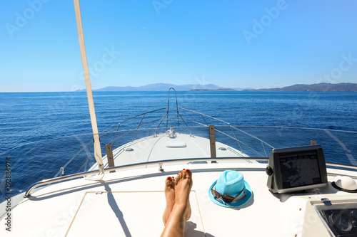 Long legs of a young woman on a yacht in the open sea having a rest start to travel with pleasure relax summer holidays concept. © vikakurylo81