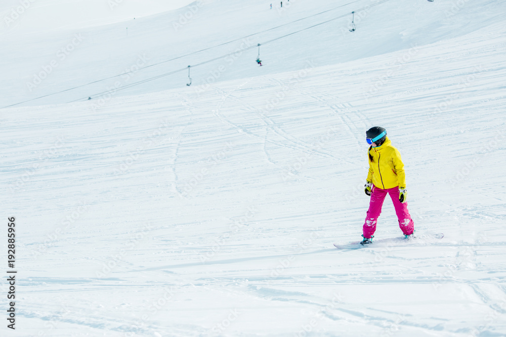 Image of young athletic girl wearing helmet in sports clothes snowboarding