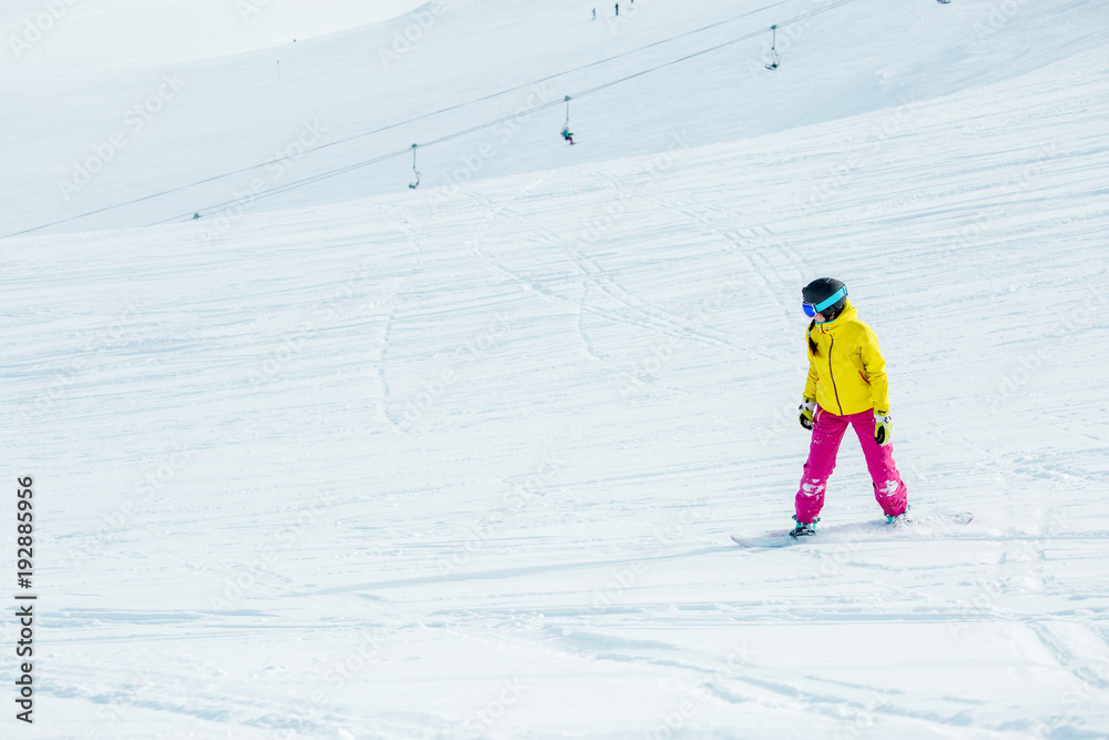 Image of young athletic girl wearing helmet in sports clothes snowboarding Image of young athletic girl wearing helmet in sports clothes snowboarding
