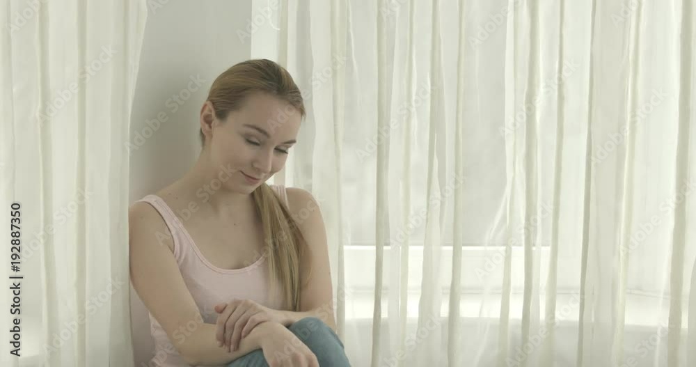 Beautiful smiling woman looking at camera at home in the living room Beautiful smiling woman looking at camera at home in the living room