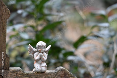Little angel sitting on a wooden christian cross © Frank Middendorf