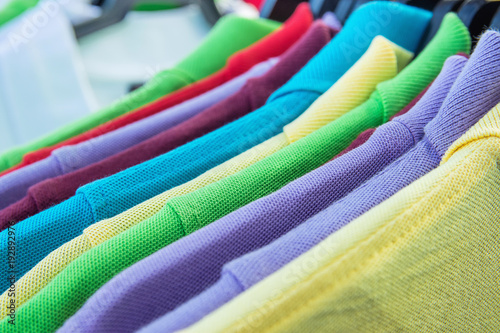 Cotton Polo Shirts of Various Colors Blue Yellow Red Purple Green White Hanging on Hangers on Rack in Clothing Store. Sales Retail Consumerism Fashion Casual Ware Concept