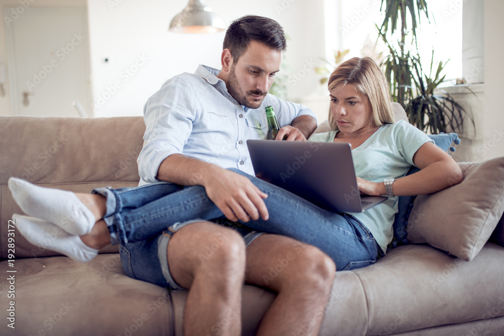 Couple on sofa using a laptop.