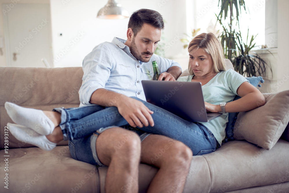 Couple on sofa using a laptop. Couple on sofa using a laptop.