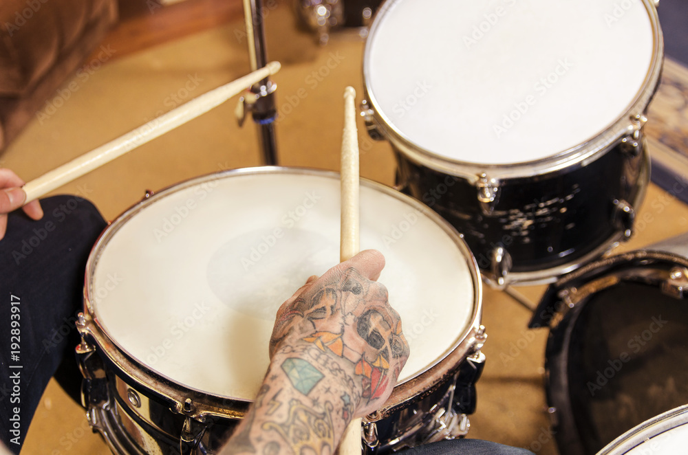Obraz premium Closeup on drummer tattooed hand and sticks 