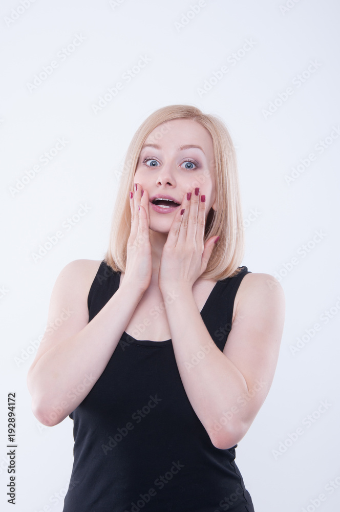 Surprised woman is touching her mouth with hands. Shocked and scared pretty girl isolated on white background. She is excited and amazed. Surprised woman is touching her mouth with hands. Shocked and scared pretty girl isolated on white background. She is excited and amazed.