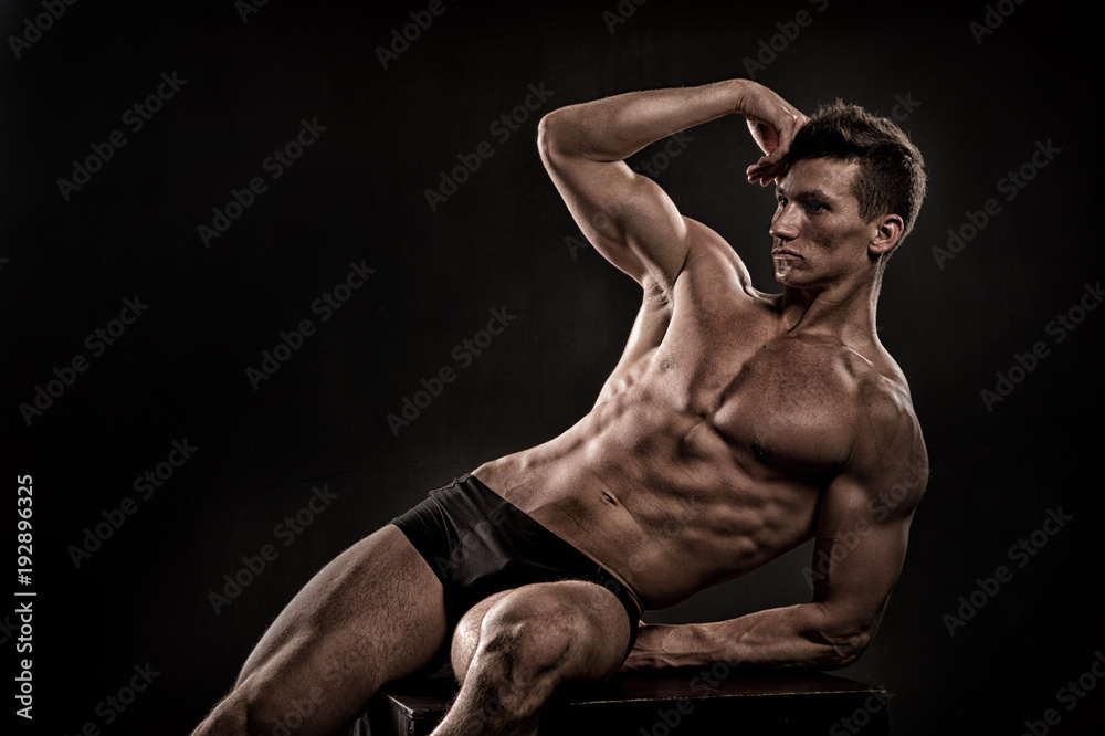 Athlete with six pack, ab on black background.