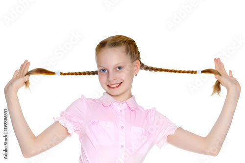 The little girl is pulling herself in pigtails.