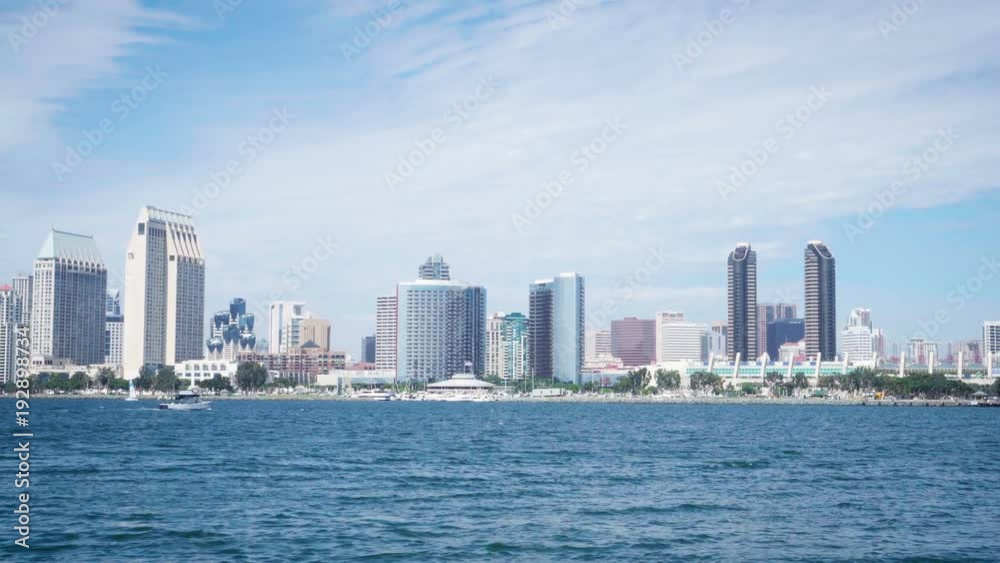 4K San Diego skyline camera slow tilt up from water to downtown buildings. 4K San Diego skyline camera slow tilt up from water to downtown buildings.