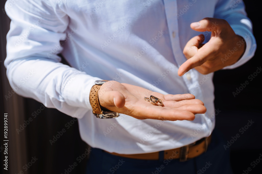 Wedding rings in the hand of the groom.