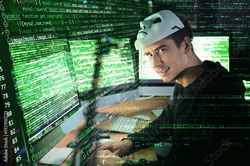Hacker with mask using comp...