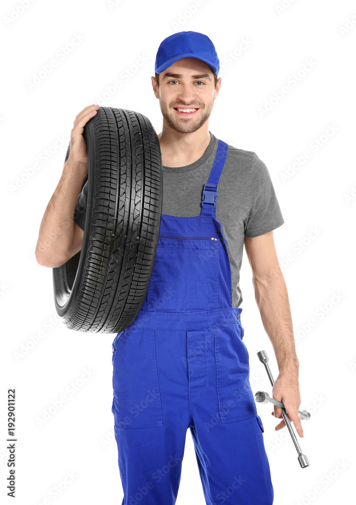 Young mechanic in uniform with car tire on white background Young mechanic in uniform with car tire on white background