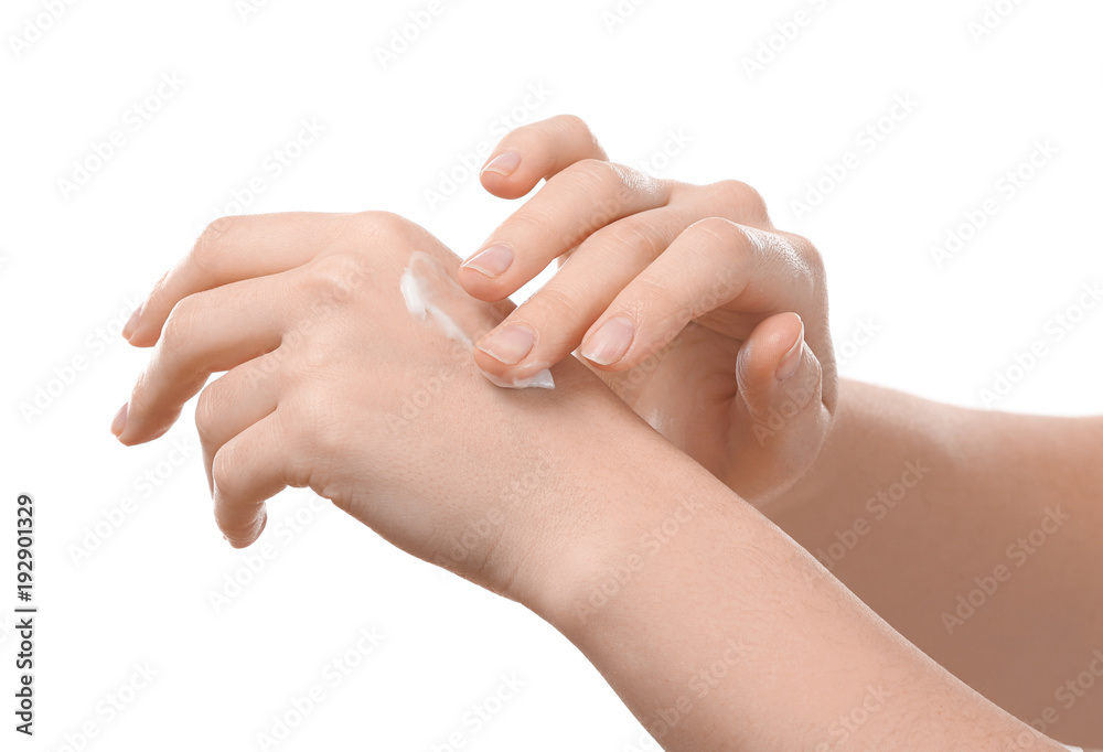 Woman applying body cream onto skin against white background