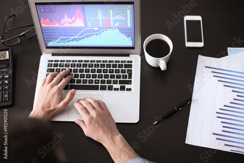 Man working at table in office, top view. Financial trading concept