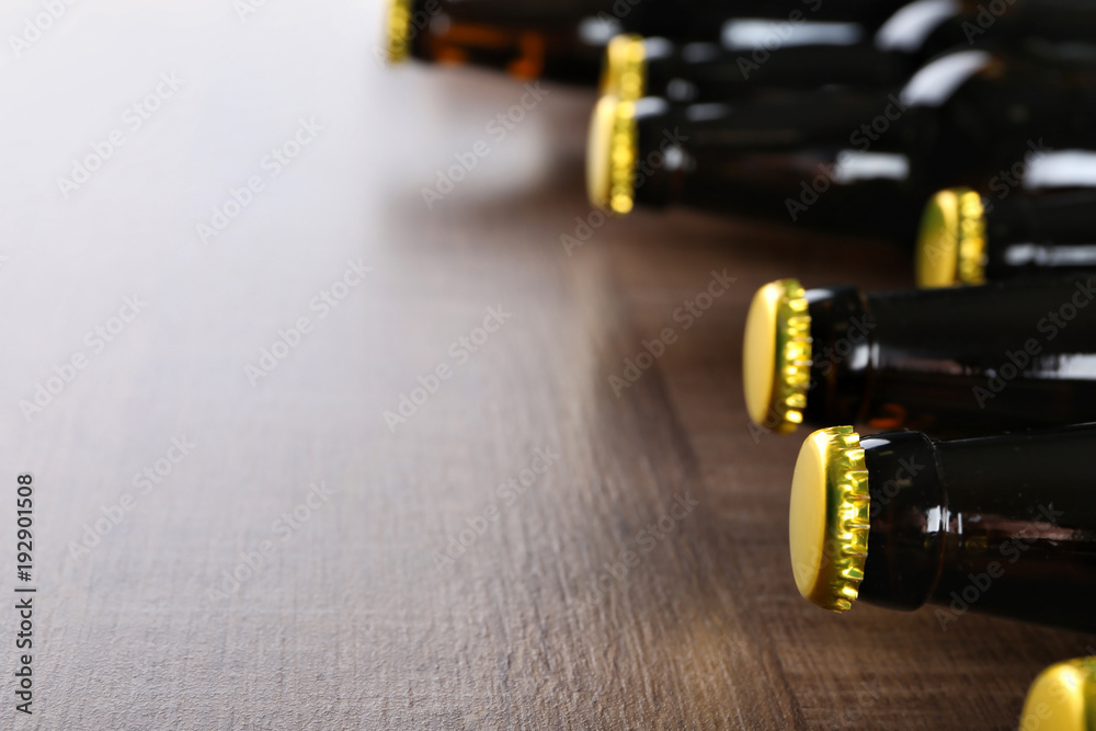Fresh beer in glass bottles on wooden background, closeup