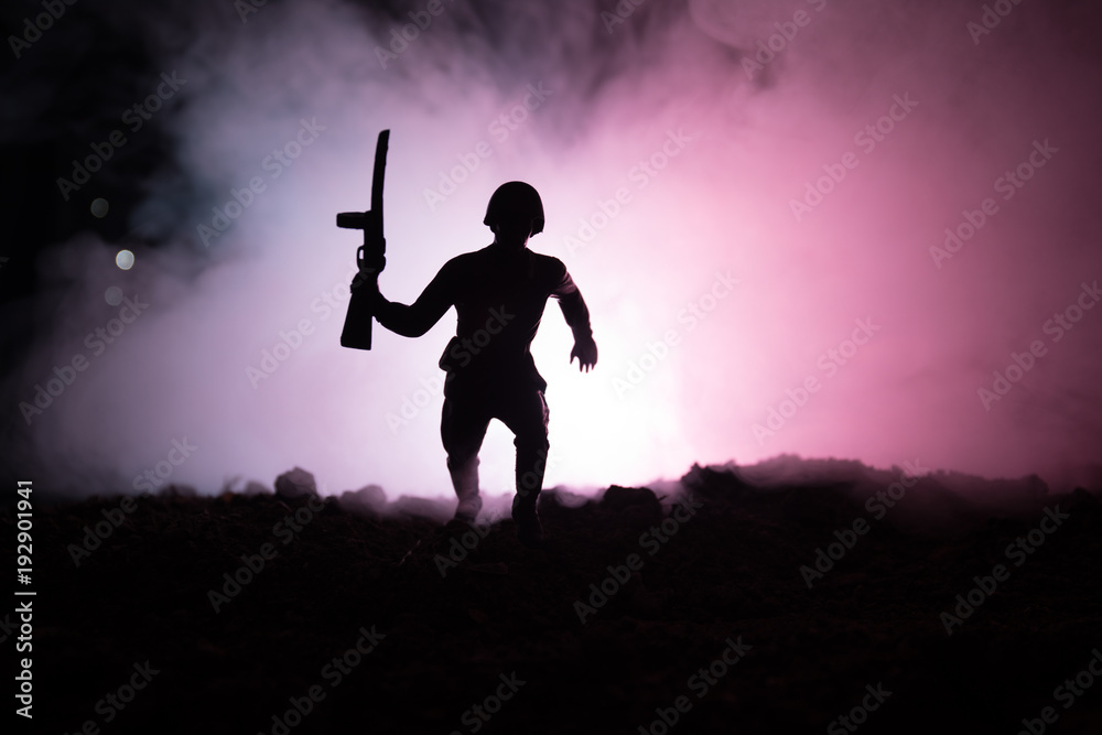 Military soldier silhouette with gun. War Concept. Military silhouettes fighting scene on war fog sky background, World War Soldier Silhouette Below Cloudy Skyline At night.