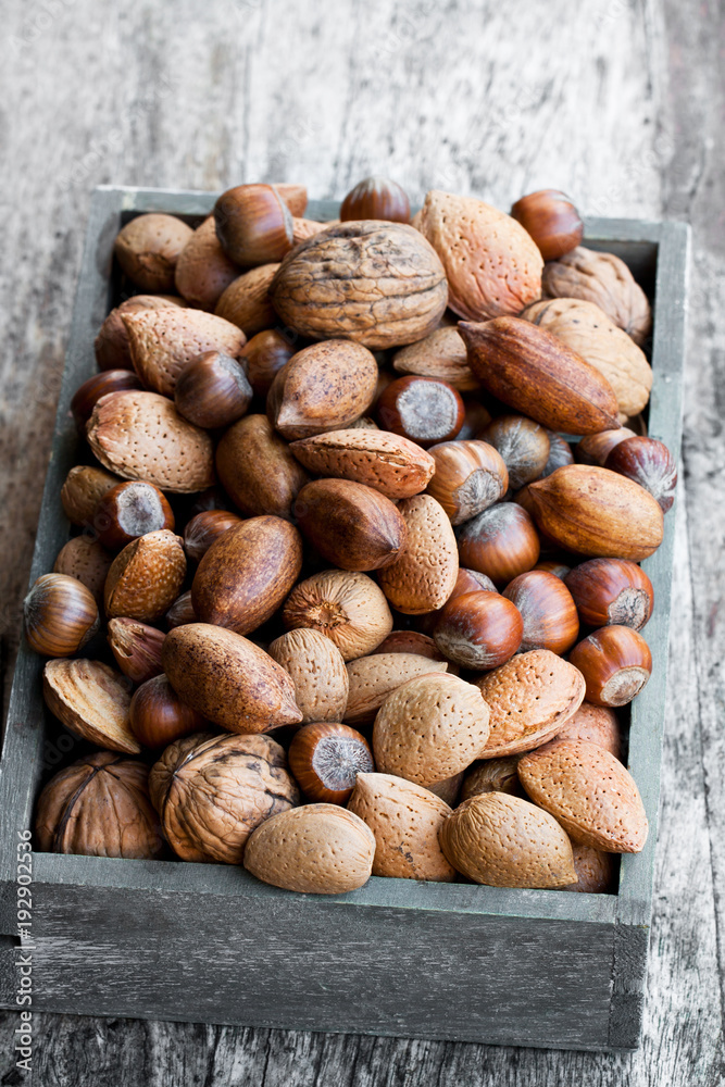 Various nuts in wooden box on rustic table Various nuts in wooden box on rustic table