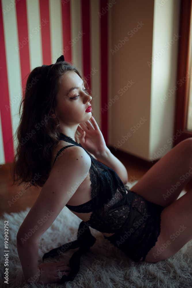 Fototapeta premium Sexy young woman in lingerie posing in the room by window