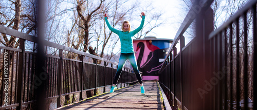 Smiling woman jumping with hands up