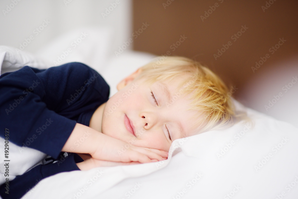 Cute little boy sleeping. Tired child taking a nap in parent's bed. Cute little boy sleeping. Tired child taking a nap in parent's bed.