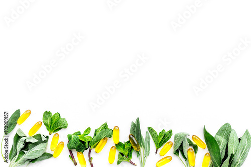 Alternative medicine. Phytotheraphy. Herbs and pills on white background top view copy space photo