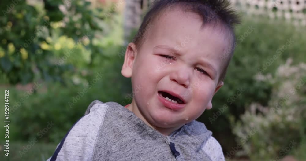 Toddler crying looks directly into camera - outdoors summer Toddler crying looks directly into camera - outdoors summer
