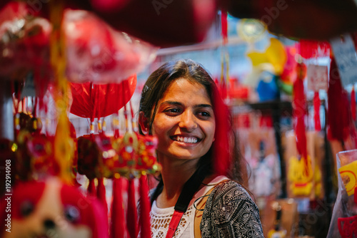 An image of a loving woman at a night market in Asia. She likes to wander around and and browse the trinkets as she happily celebrates the Chinese New Year.