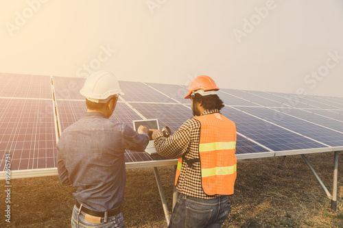 solar power plant to innovation of green energy; engineer or electrician working on checking and maintenance equipment at solar power plant