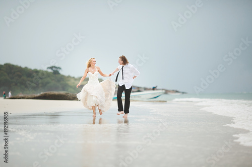 the couple running on the sea. Wedding on a deserted beach.