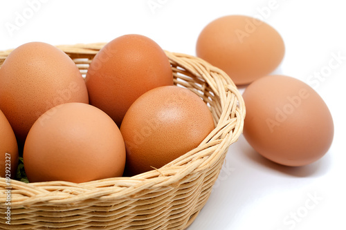 Eggs in the wicker basket on white background for healthy food concept