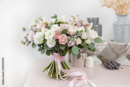 beautiful luxury bouquet of mixed flowers on pink table. the work of the florist at a flower shop. Wedding © malkovkosta