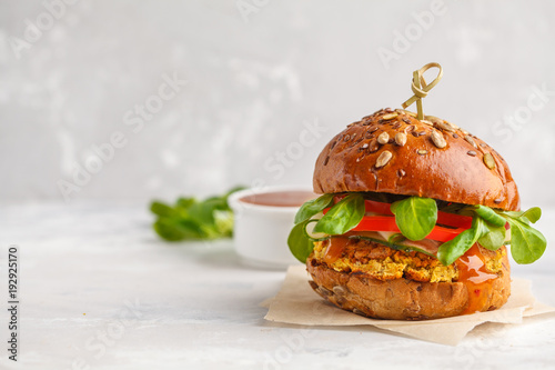 Vegan lentils burger with vegetables and curry sauce. Light background, copy space. Healthy vegan food concept.
