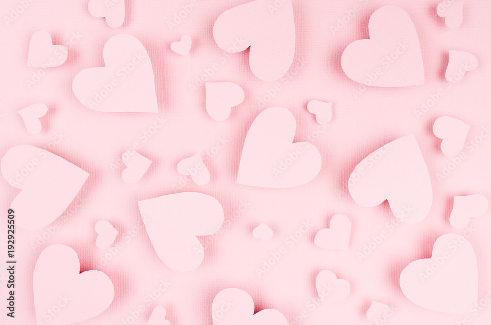 Valentine day background of many different paper hearts on pink soft background.