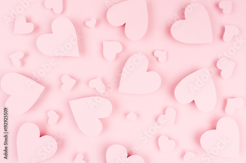 Valentine day background of many different paper hearts on pink soft background.