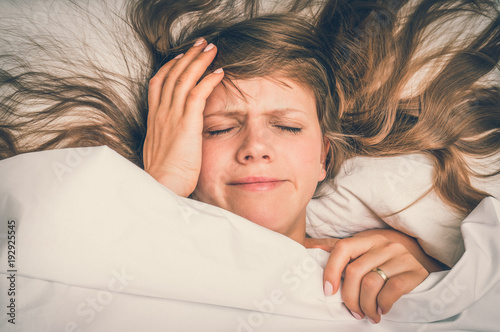 Woman in bed having headache in the morning photo