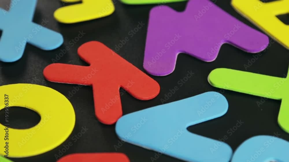 different color letters on a black background. The video rotation different color letters on a black background. The video rotation