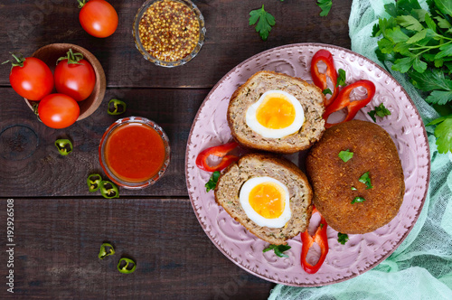 Large juicy cutlets stuffed with boiled egg on a dark wooden background. Scottish cutlet. The top view