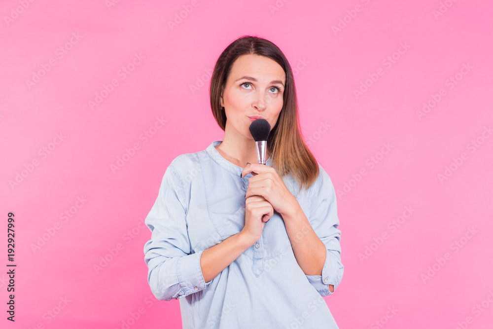 Professional makeup artist with brushes on pink background Professional makeup artist with brushes on pink background