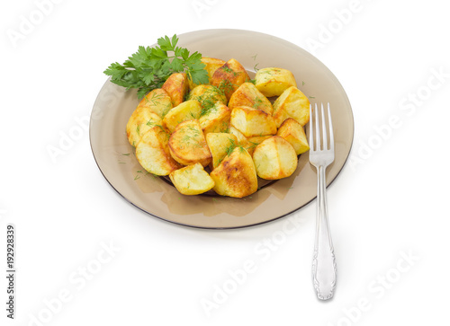 Fried potatoes on dark glass dish and fork