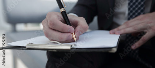 Businessman signs a contract. Holding pen in hand.
